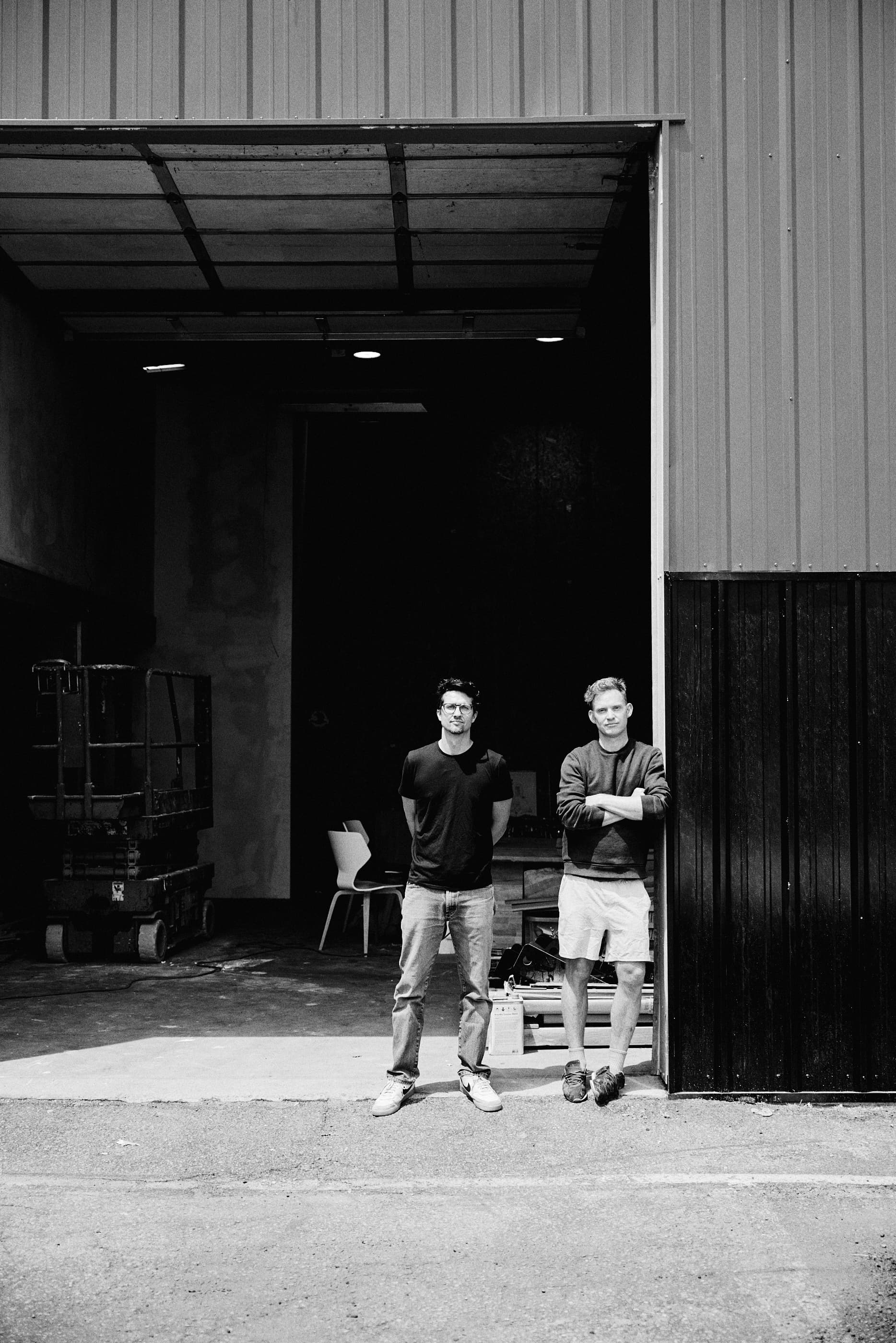 Migration Studios founders standing at the entrance of their workshop